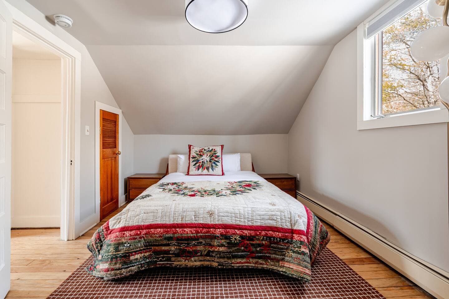 Cozy loft bedroom with queen bed and handmade quilt at The Cedar Stock Cabin