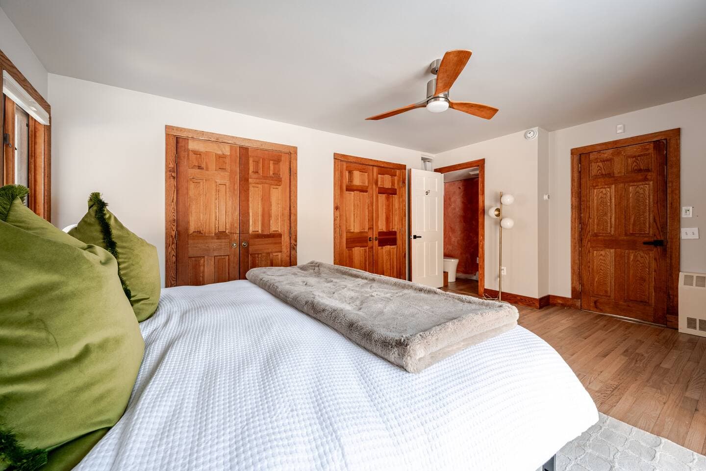 Master bedroom with king bed, cedar closet doors, and en-suite bathroom at The Cedar Stock Cabin